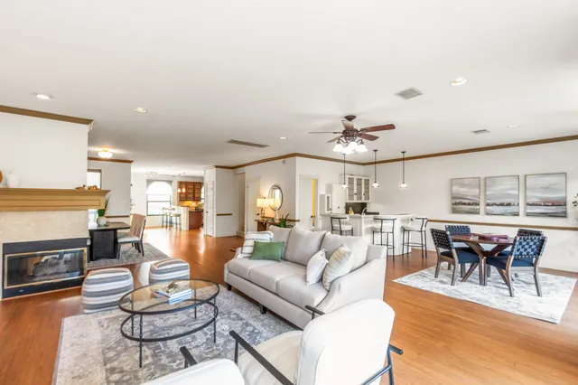 a living room with furniture dining table a fireplace and a large window