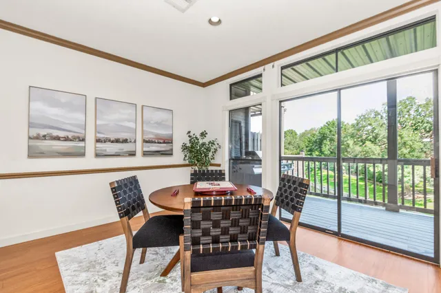 a dining room with furniture large windows and wooden floor