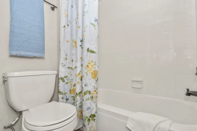 a white toilet sitting next to a bath tub