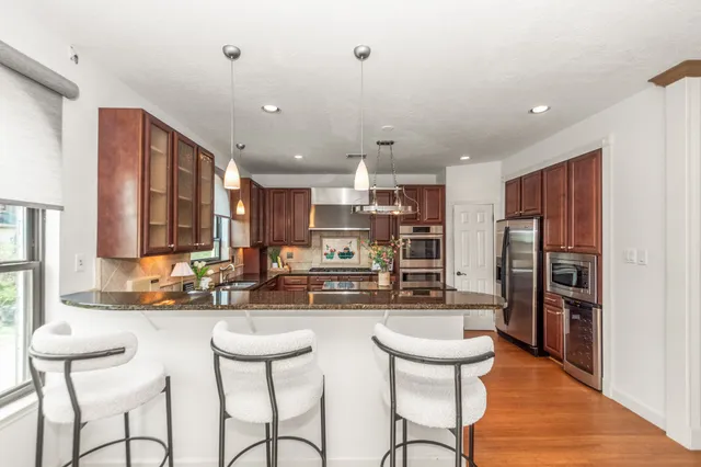 a kitchen with stainless steel appliances granite countertop a sink stove and refrigerator