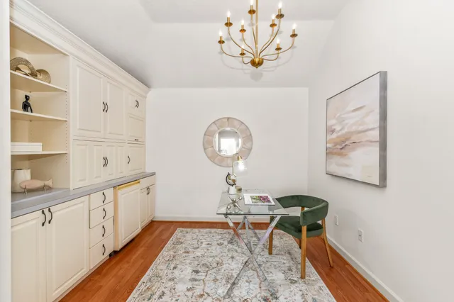 a view of a hallway with wooden floor and a chandelier