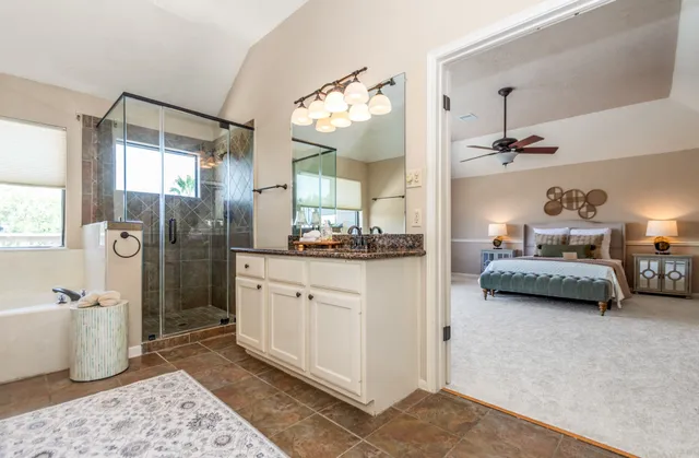 a bathroom with a tub shower sink and mirror