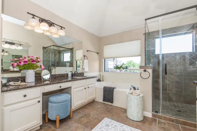 a bathroom with a double vanity sink mirror and shower