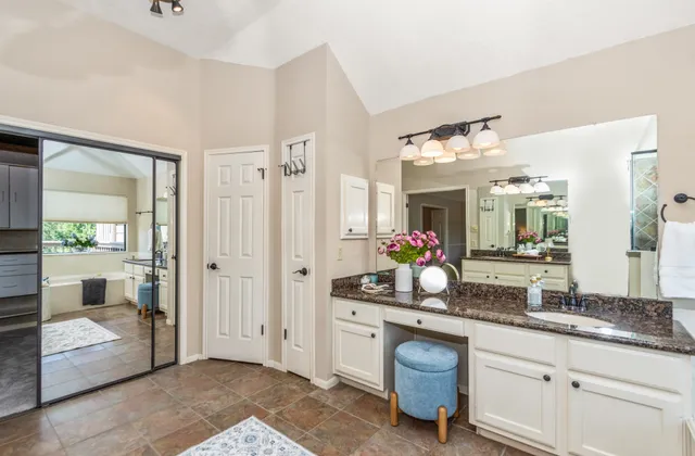 a spacious bathroom with a granite countertop sink a mirror and a shower