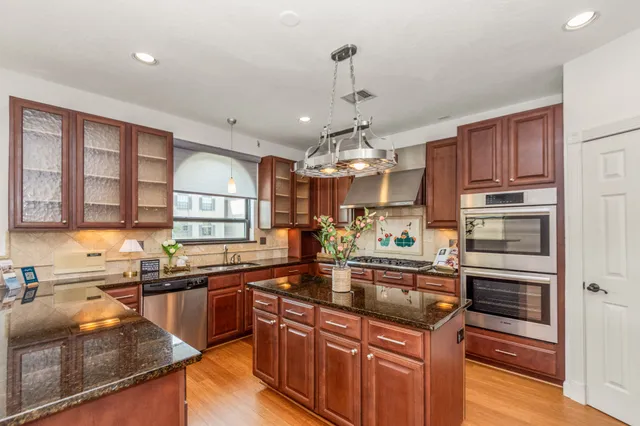 a kitchen with stainless steel appliances granite countertop a sink refrigerator and cabinets