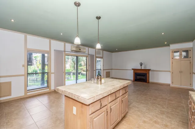 a kitchen with kitchen island a counter top space appliances and a center island