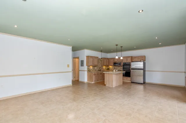 a view of a kitchen with a sink and a refrigerator
