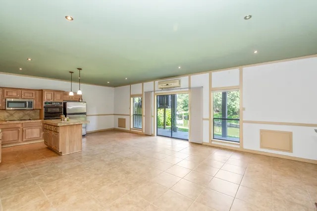 a kitchen with stainless steel appliances kitchen island granite countertop a sink and cabinets