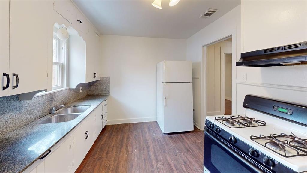 2246 Anson Road Dallas, TX 75235 - Photo 8 of 20 Kitchen featuring wood-finish flooring, white cabinetry, and speckled countertops