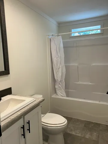 a bathroom with a granite countertop toilet and a sink