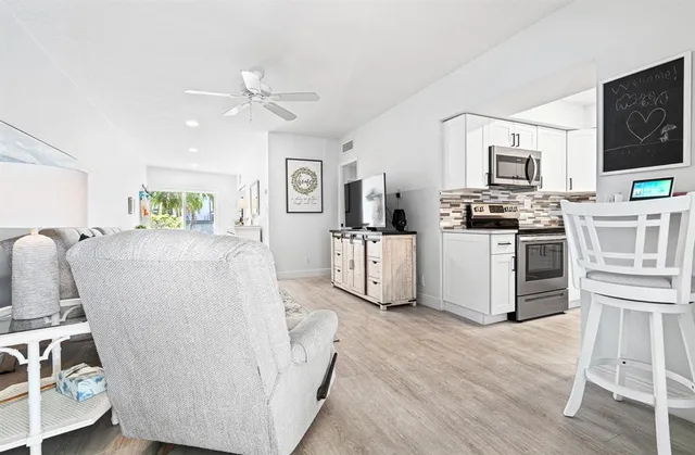 a living room with furniture a flat screen tv and kitchen view