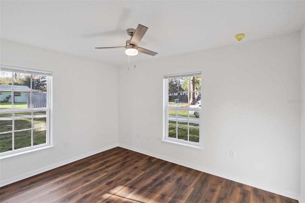 1075 North Rockingham Avenue Tavares, FL 32778 - Photo 11 of 16 a view of an empty room with a window and wooden floor
