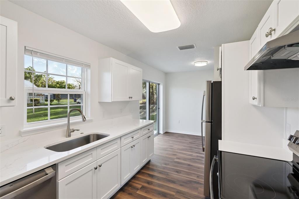 1075 North Rockingham Avenue Tavares, FL 32778 - Photo 7 of 16 a kitchen with sink cabinets and window
