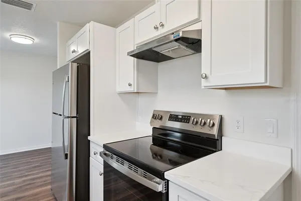 a kitchen with stainless steel appliances white cabinets and a stove