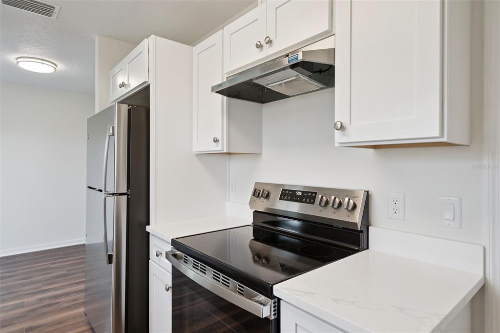 1075 North Rockingham Avenue Tavares, FL 32778 - Photo 9 of 16 a kitchen with stainless steel appliances white cabinets and a stove