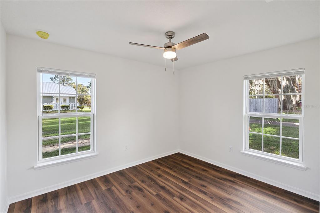 1075 North Rockingham Avenue Tavares, FL 32778 - Photo 10 of 16 an empty room with wooden floor and windows