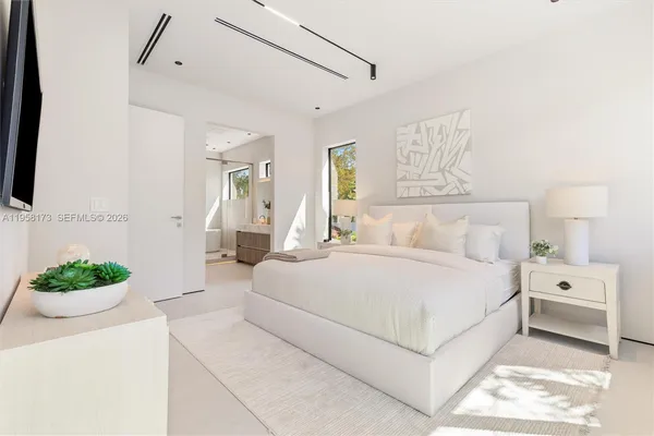 a bedroom with a bed and a large window