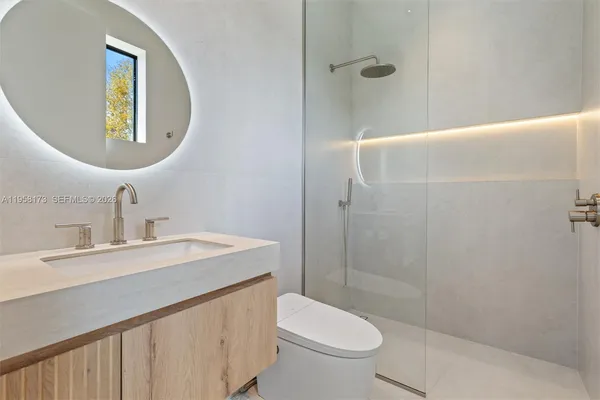 a bathroom with a toilet a sink and mirror