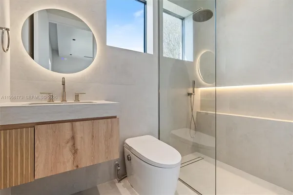 a bathroom with a granite countertop sink mirror and a bathtub