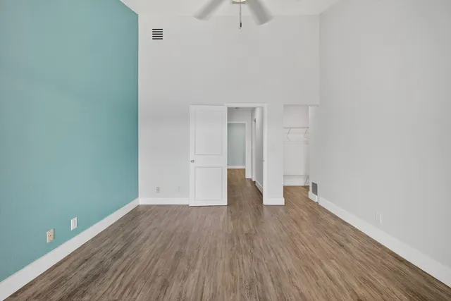 a view of empty room with wooden floor and window