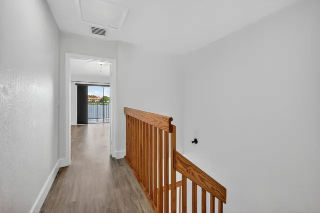 a view of a hallway with wooden floor
