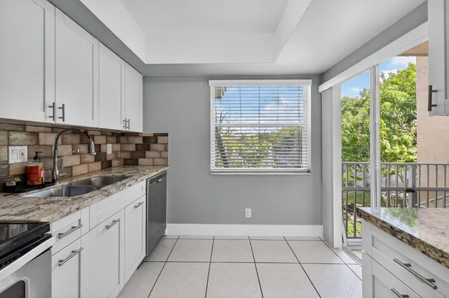 a kitchen with granite countertop a stove a sink and a cabinets