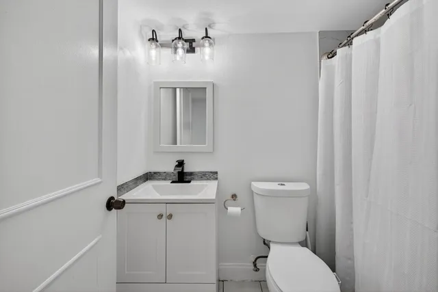 a bathroom with a toilet sink and mirror