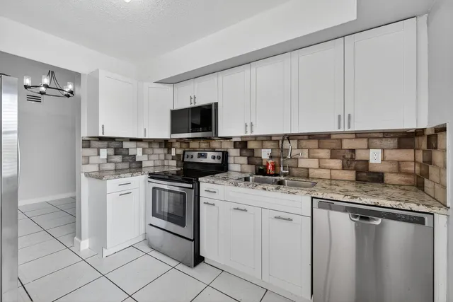 a kitchen with appliances a sink and cabinets