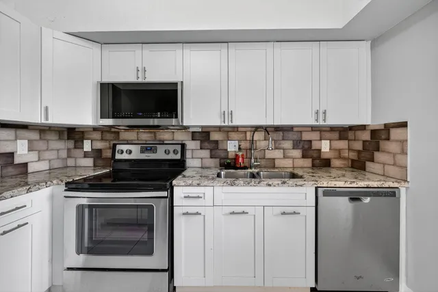a kitchen with cabinets appliances a sink and a counter top