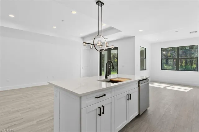 a kitchen with kitchen island granite countertop white cabinets and stainless steel appliances