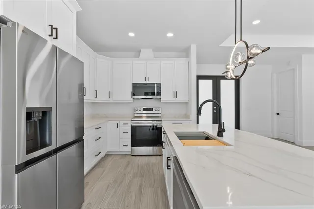 a kitchen with stove cabinets and stainless steel appliances