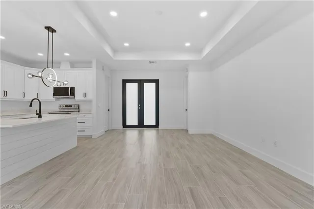 a kitchen with stainless steel appliances granite countertop a white sink and wooden floors
