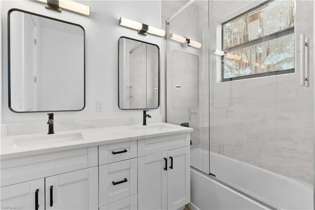a bathroom with a double vanity sink mirror and shower