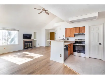 a kitchen with granite countertop a stove top oven a sink dishwasher a dining table and chairs with wooden floor