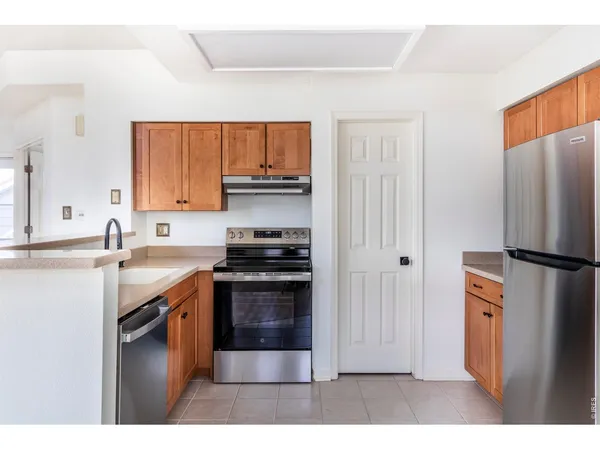 a kitchen with stainless steel appliances granite countertop a refrigerator stove and sink