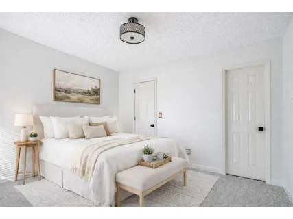 a bedroom with a bed and a painting on the wall