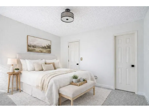 a bedroom with a bed and a painting on the wall