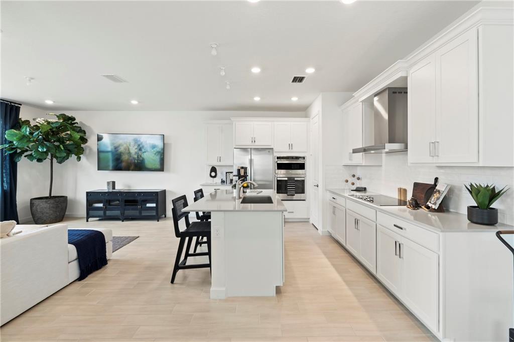 a large white kitchen with lots of counter space a sink and appliances