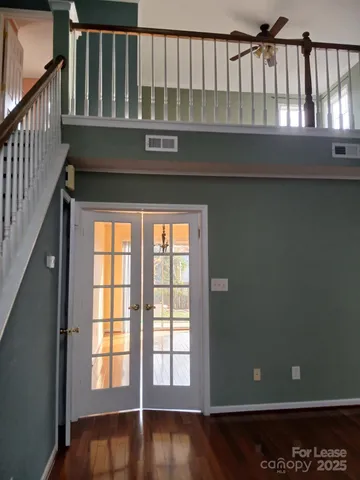 en empty room with windows and ceiling fan