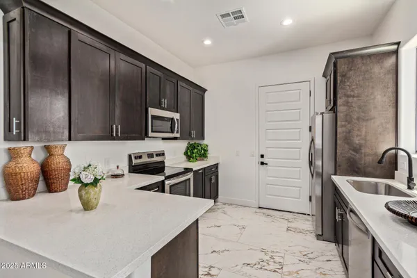 a kitchen with stainless steel appliances granite countertop a sink a stove and a refrigerator