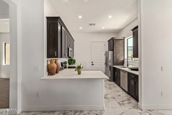 a large kitchen with granite countertop a sink and stainless steel appliances