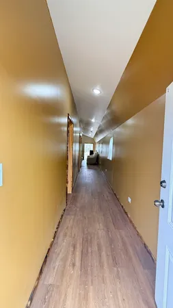 a view of a hallway with wooden floor