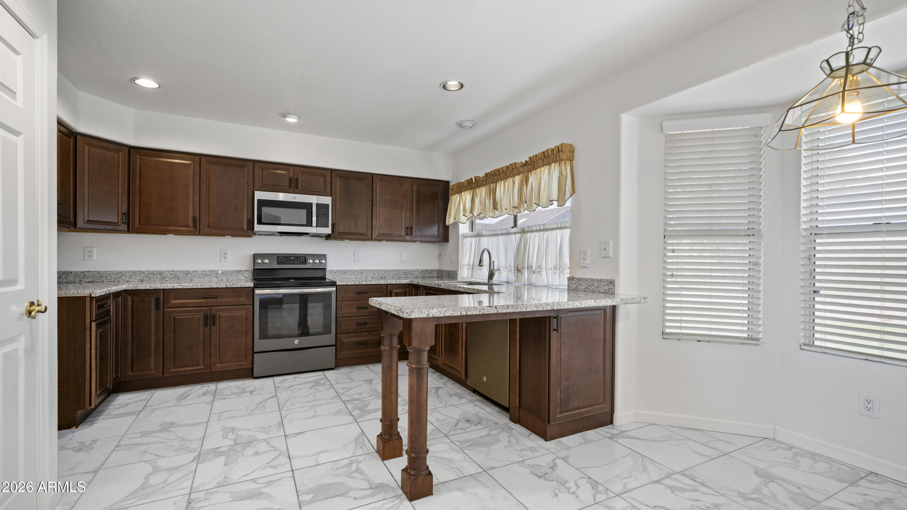 6620 West Redfield Road Glendale, AZ 85306 - Photo 5 of 33 a kitchen with a sink a stove a microwave and cabinets
