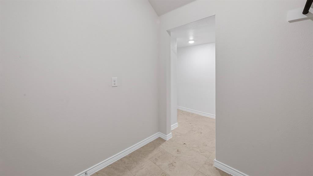 412 Carthage Street Caddo Mills, TX 75135 - Photo 17 of 32 Hallway with light-colored walls, white baseboards, and neutral-toned flooring