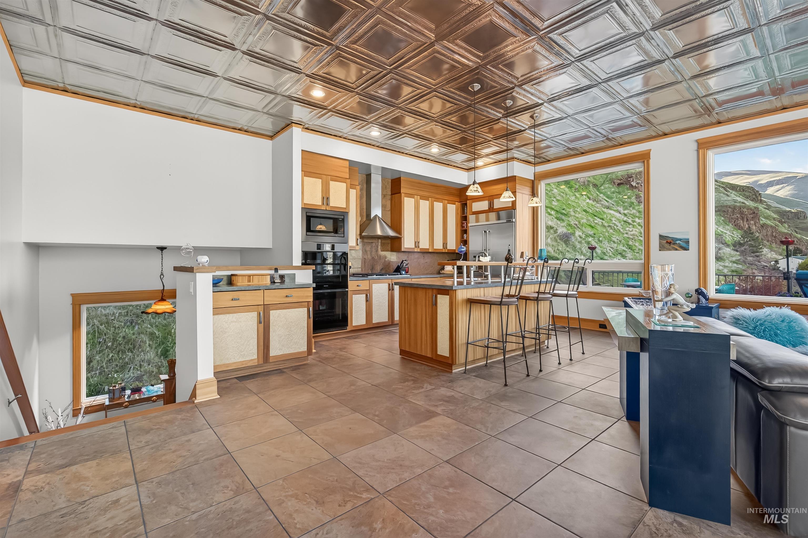 6382 Snake River Road Asotin, WA 99402 - Photo 12 of 34 Kitchen featuring a breakfast bar, an ornate ceiling, a kitchen island, built in appliances, and decorative light fixtures