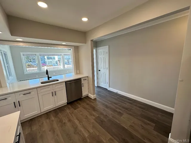 a large kitchen with wooden floor and a sink