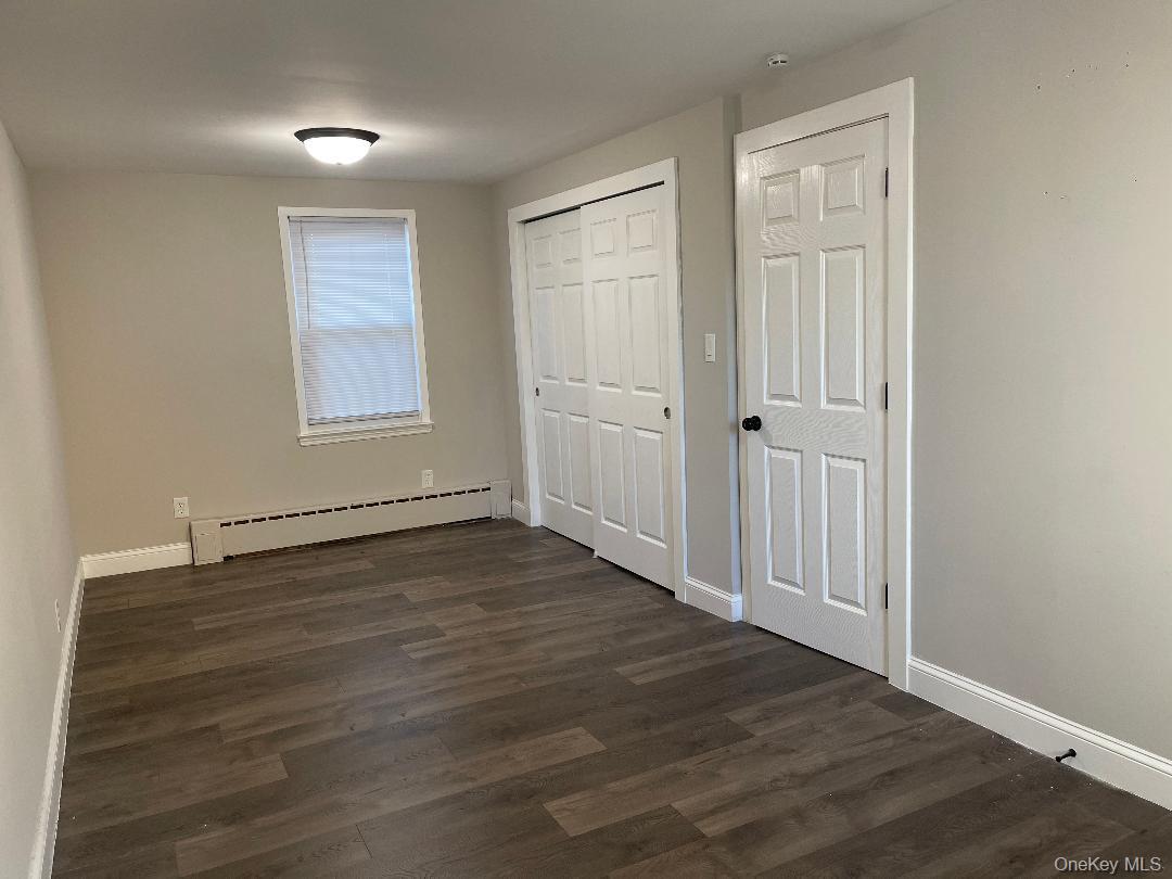 84 Rochester Avenue, Unit MAIN Long Beach, NY 11561 - Photo 17 of 27 an empty room with wooden floor and windows
