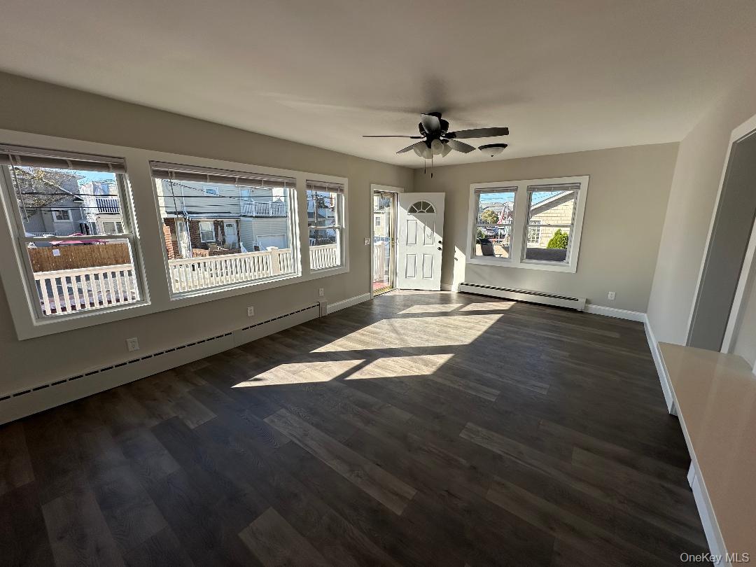 84 Rochester Avenue, Unit MAIN Long Beach, NY 11561 - Photo 2 of 27 a view of an empty room with a window and a kitchen