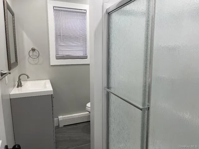 a bathroom with a sink and mirror with toilet