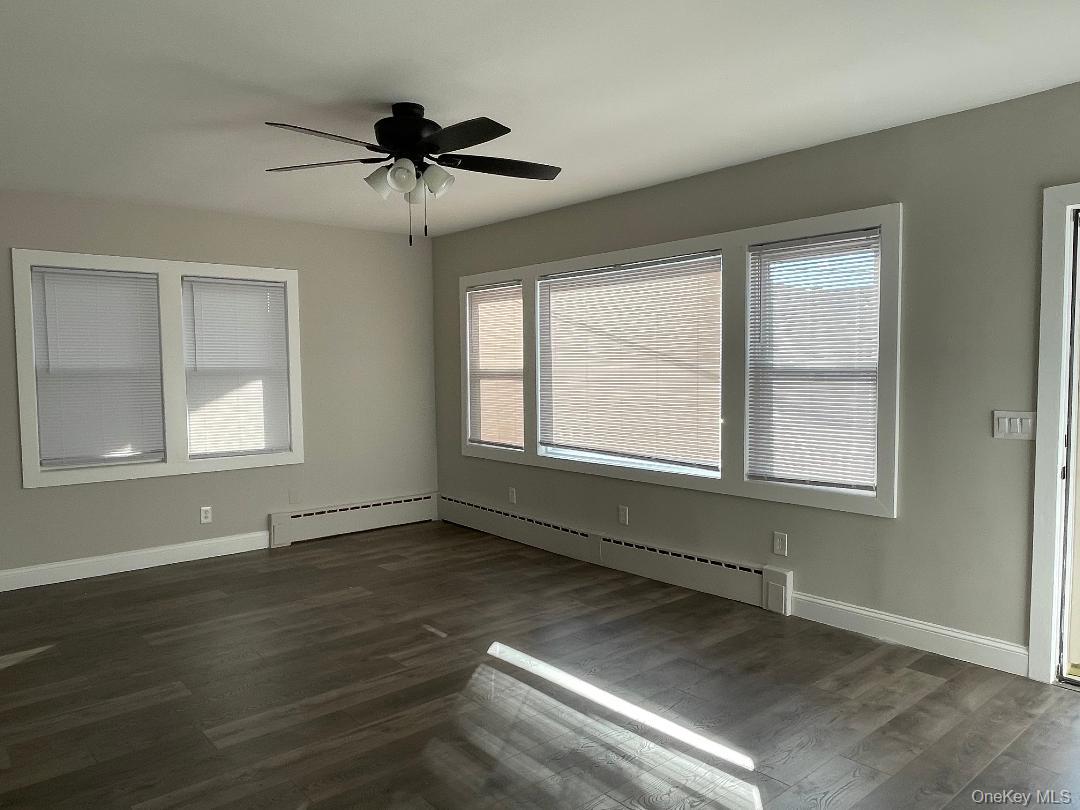 84 Rochester Avenue, Unit MAIN Long Beach, NY 11561 - Photo 3 of 27 a view of an empty room with wooden floor and a window